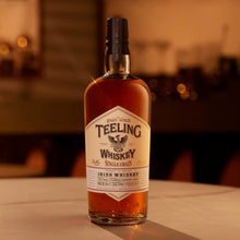 Load image into Gallery viewer, Teeling Single Grain Whiskey bottle on a bar counter with blurred bar background