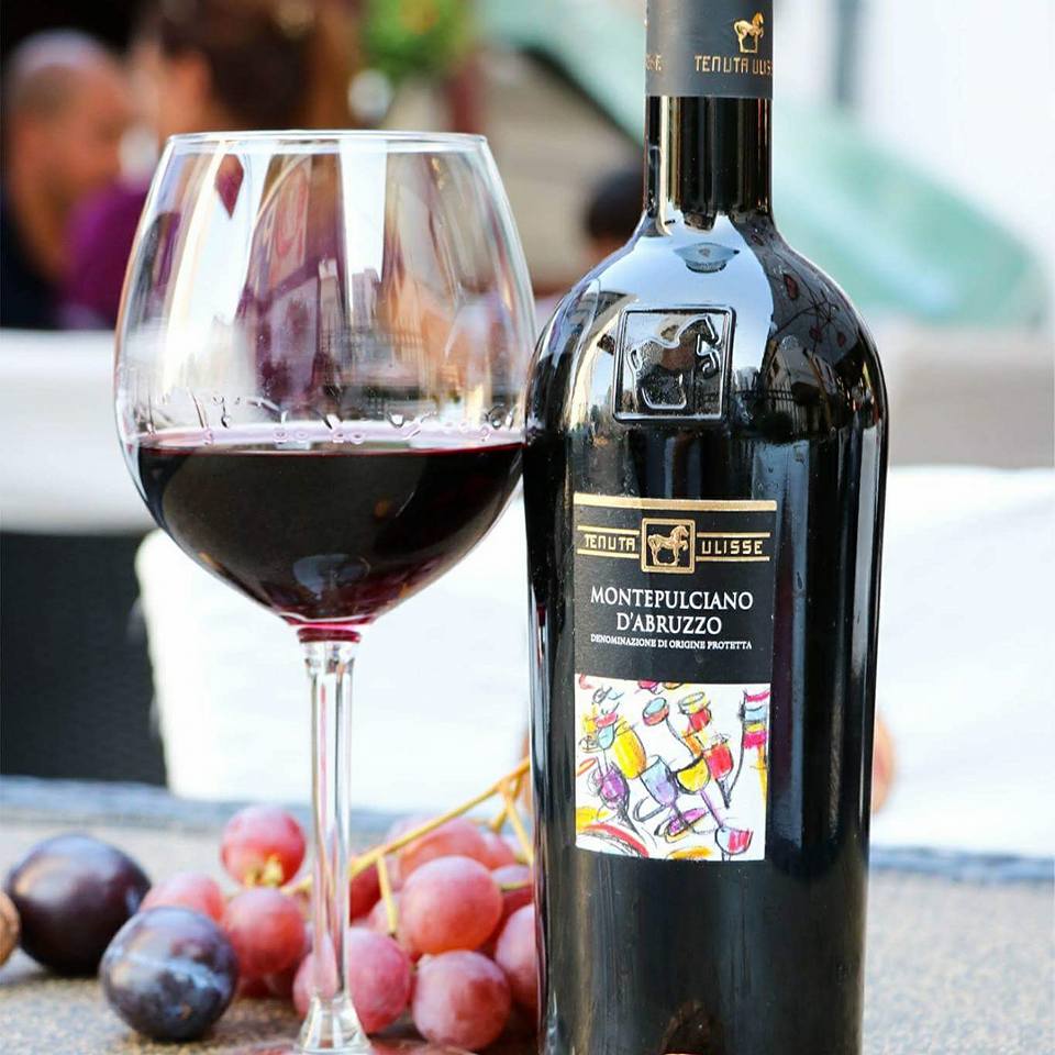 Load image into Gallery viewer, a bottle of Tenuta Ulisse Montepulciano d'Abruzzo next to a wine glass and grapes