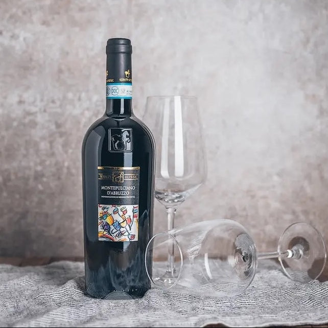 Load image into Gallery viewer, Bottle of Tenuta Ulisse Montepulciano d'Abruzzo wine with two glasses on a textured surface.