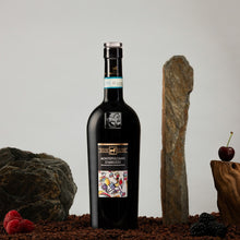 Load image into Gallery viewer, A bottle of Tenutra Ulisse Montepulciano  red wine on a textured surface with stones and berries