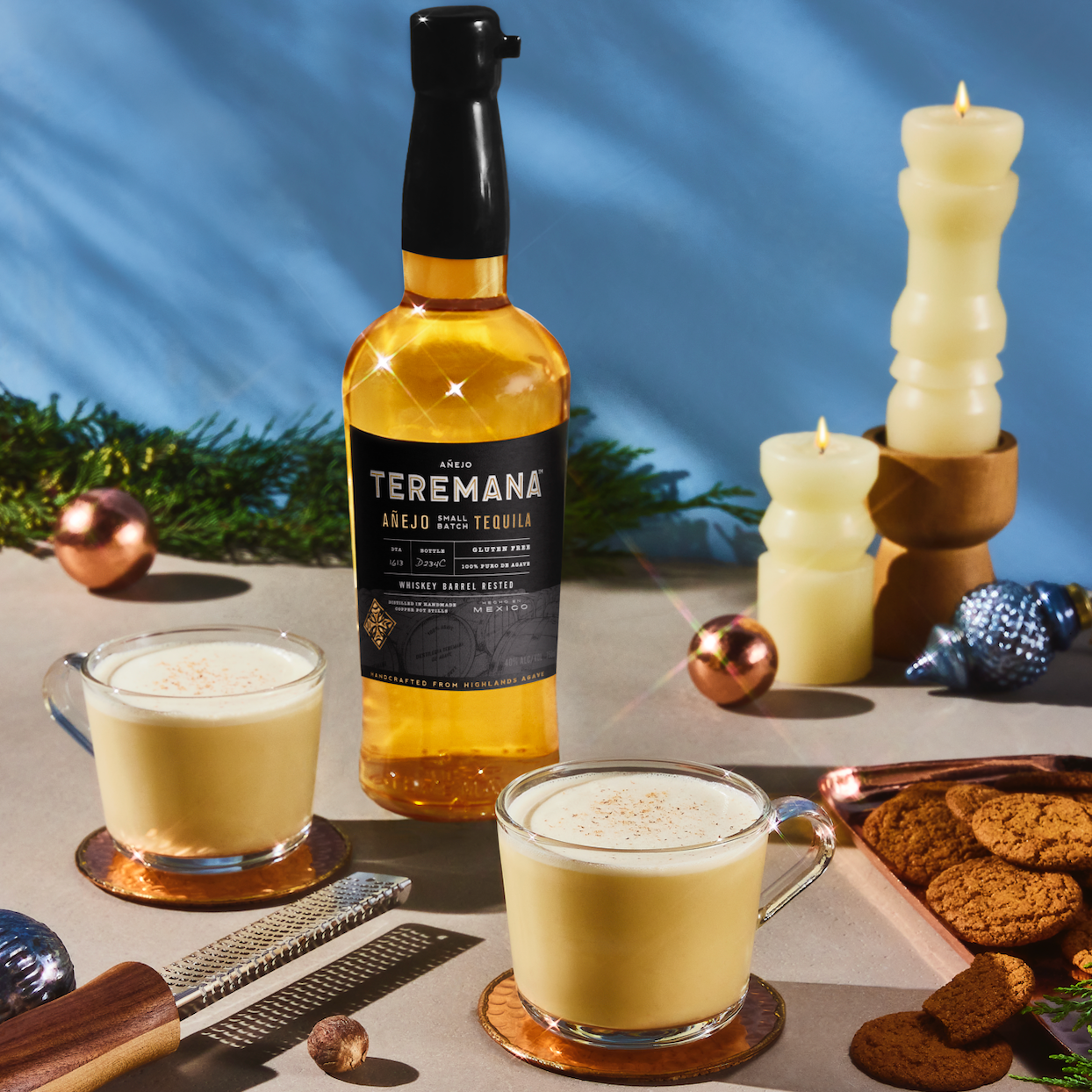 Load image into Gallery viewer, Bottle of Teremana anejo tequila with two glasses of a creamy beverage on a table with cookies and candles.