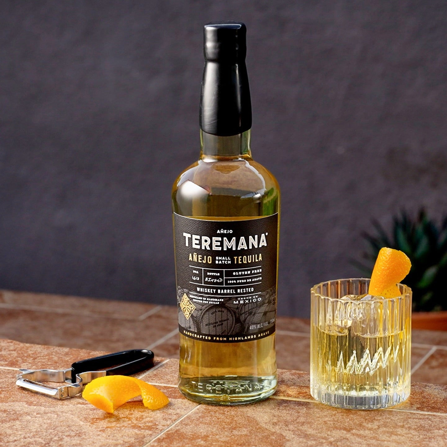 Load image into Gallery viewer, Teremana anejo tequila bottle with a cocktail on a wooden surface