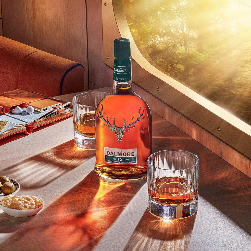 Dalmore 15 YEAR OLD whisky bottle with glasses on a wooden table