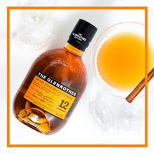 Load image into Gallery viewer, Bottle of The Glenrothes whisky with a glass of orange liquid and cinnamon stick on a white background