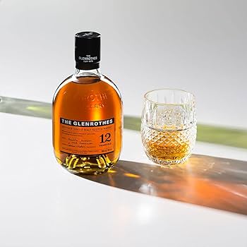 Bottle and glass of Glenrothes whiskey on a reflective surface with a neutral background