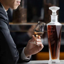 Load image into Gallery viewer, Person holding a glass of whiskey next to a decanter with a blurred background