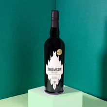 Load image into Gallery viewer, Bottle of Thomson Manuka Smoke whiskey on a green background