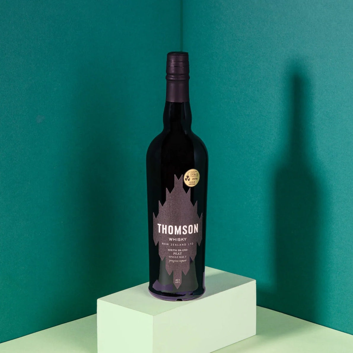 Load image into Gallery viewer, A bottle of Thomson New Zealand Whisky with a teal background