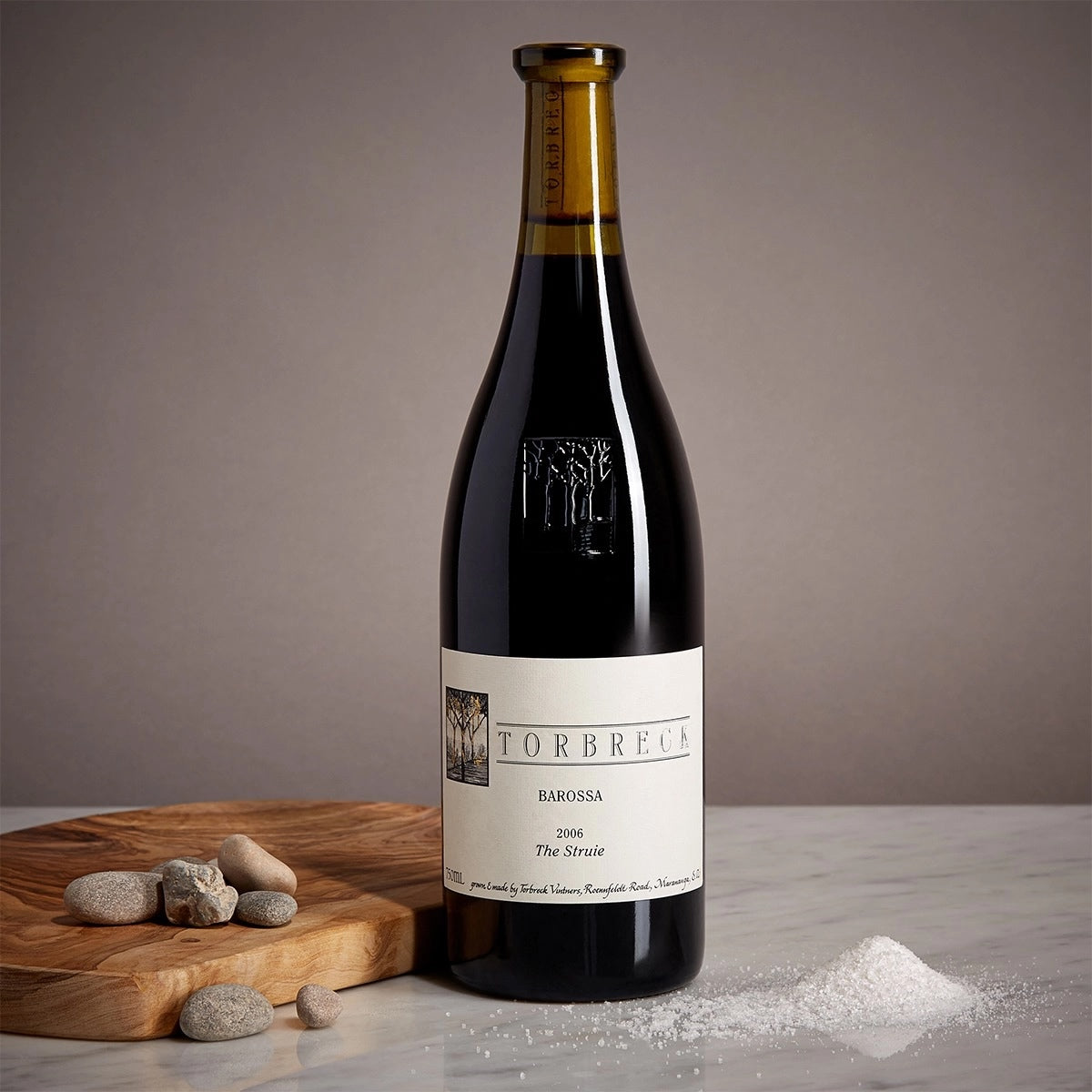 Load image into Gallery viewer, Wine bottle with label on a wooden cutting board against a gray background