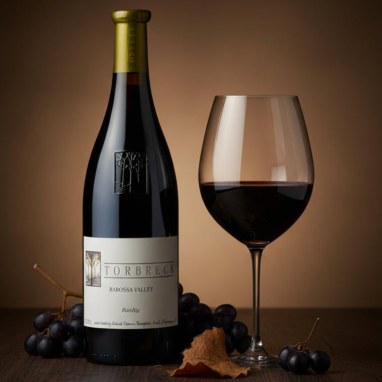 Torbreck_RunRig_Shiraz wine bottle and glass with grapes on a wooden surface