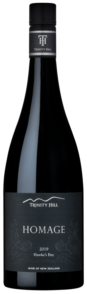A bottle of Trinity Hill 'Homage' Syrah wine with a black label featuring the Trinity Hill logo.