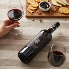 Load image into Gallery viewer, Bottle of Trinity Hill Prison Block Cabernet Sauvignon wine with two glasses and a snack platter on a table.