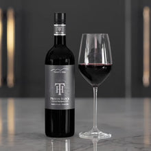 Load image into Gallery viewer, Trinity Hill Prison Block Cabernet Sauvignon wine bottle with a glass of red wine on a reflective surface.