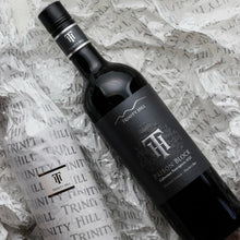 Load image into Gallery viewer, Trinity Hill Prison Block Cabernet Sauvignon wine bottle on tissue paper with visible branding.