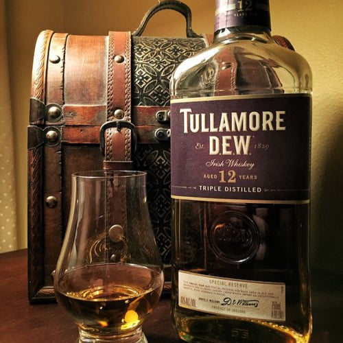 Load image into Gallery viewer, Bottle of Tullamore Dew Irish whiskey with a glass and wooden chest.