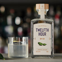 Load image into Gallery viewer, Twelfth Hour Dry Gin bottle with a glass of gin and tonic on a bar counter.