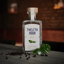 Load image into Gallery viewer, Twelfth Hour gin bottle with botanicals on a wooden surface
