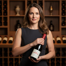 Load image into Gallery viewer, Woman holding a bottle of &#39;Two Paddocks&#39; wine in a wine cellar.