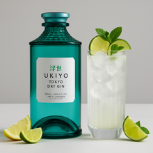 Load image into Gallery viewer, Ukiyo Tokyo Dry Gin bottle with a glass of gin and tonic garnished with lime and mint leaves on a light background.
