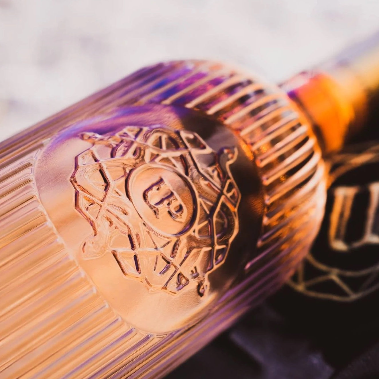 Load image into Gallery viewer, Close-up of a bottle of rose with a brand logo on a blurred background
