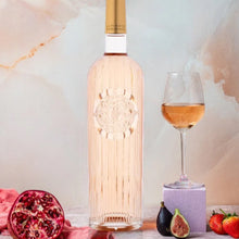 Load image into Gallery viewer, Bottle of rose wine with a glass, pomegranate, figs, and strawberries on a marble surface.