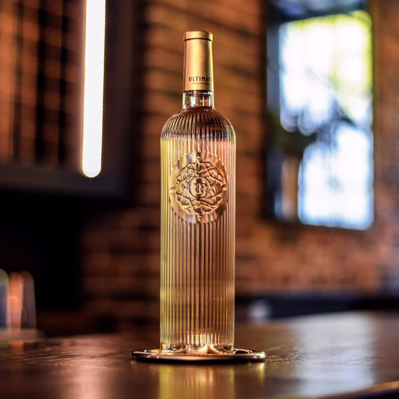 Load image into Gallery viewer, Decorative bottle of rose wine with intricate design on a wooden surface