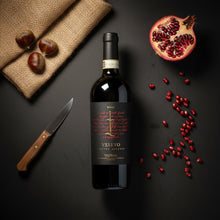 Load image into Gallery viewer, Vesevo Ensis Taurasi red wine bottle with pomegranate seeds and a knife on a dark surface