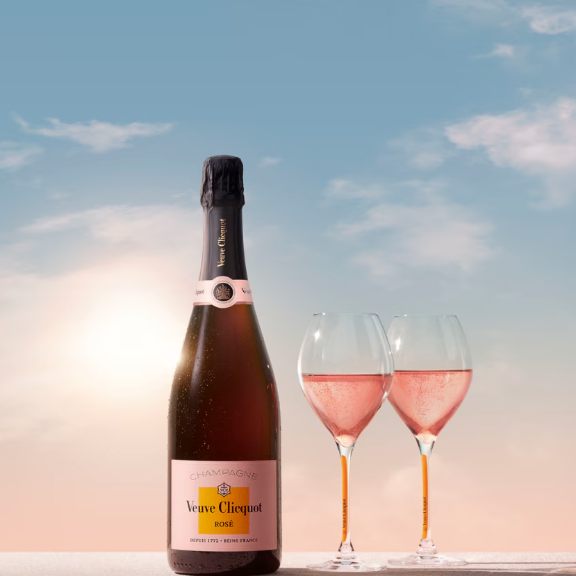 Load image into Gallery viewer, A bottle of Veuve Clicquot Brut Rosé Champagne and two glasses with a blue sky in the background