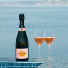 Load image into Gallery viewer, Bottle of Veuve Clicquot rosé champagne with two glasses of champagne by a pool with ocean view