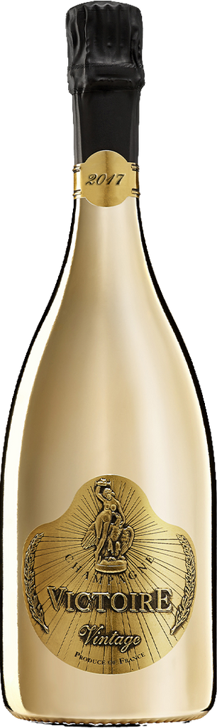 A gold bottle of Victoire Fût de Chêne Prestige Champagne with a metallic gold foil label, a black cork, and a gold foil seal marked 2017, isolated on a white background.