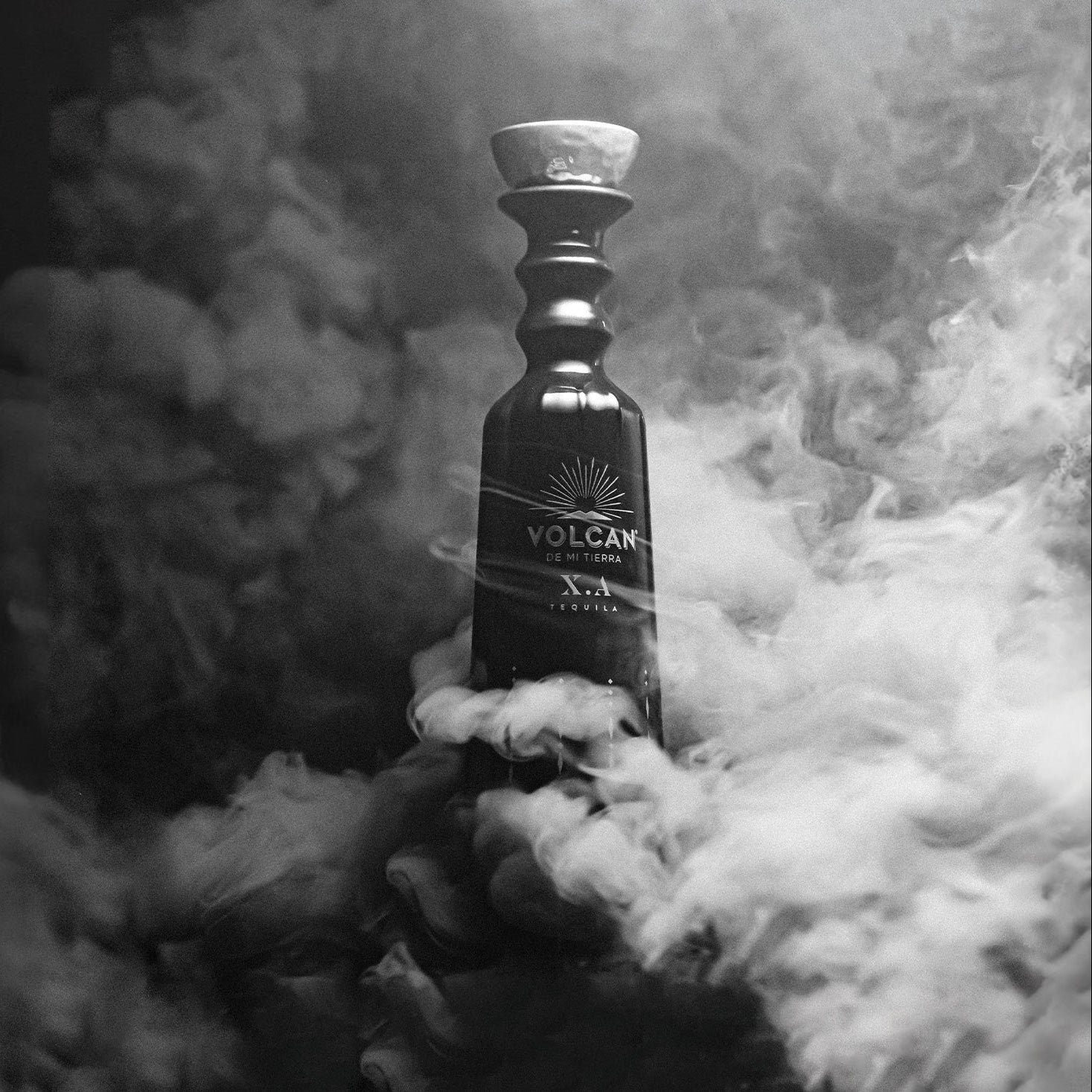 Load image into Gallery viewer, Bottle of Volcán de mi Tierra X.A Tequila surrounded by smoke on a dark background