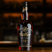 Load image into Gallery viewer, Weller 12-year-old bourbon bottle on a wooden surface with a blurred background