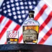 Load image into Gallery viewer, WhistlePig Rye Whiskey bottle with a glass in front of an American flag background