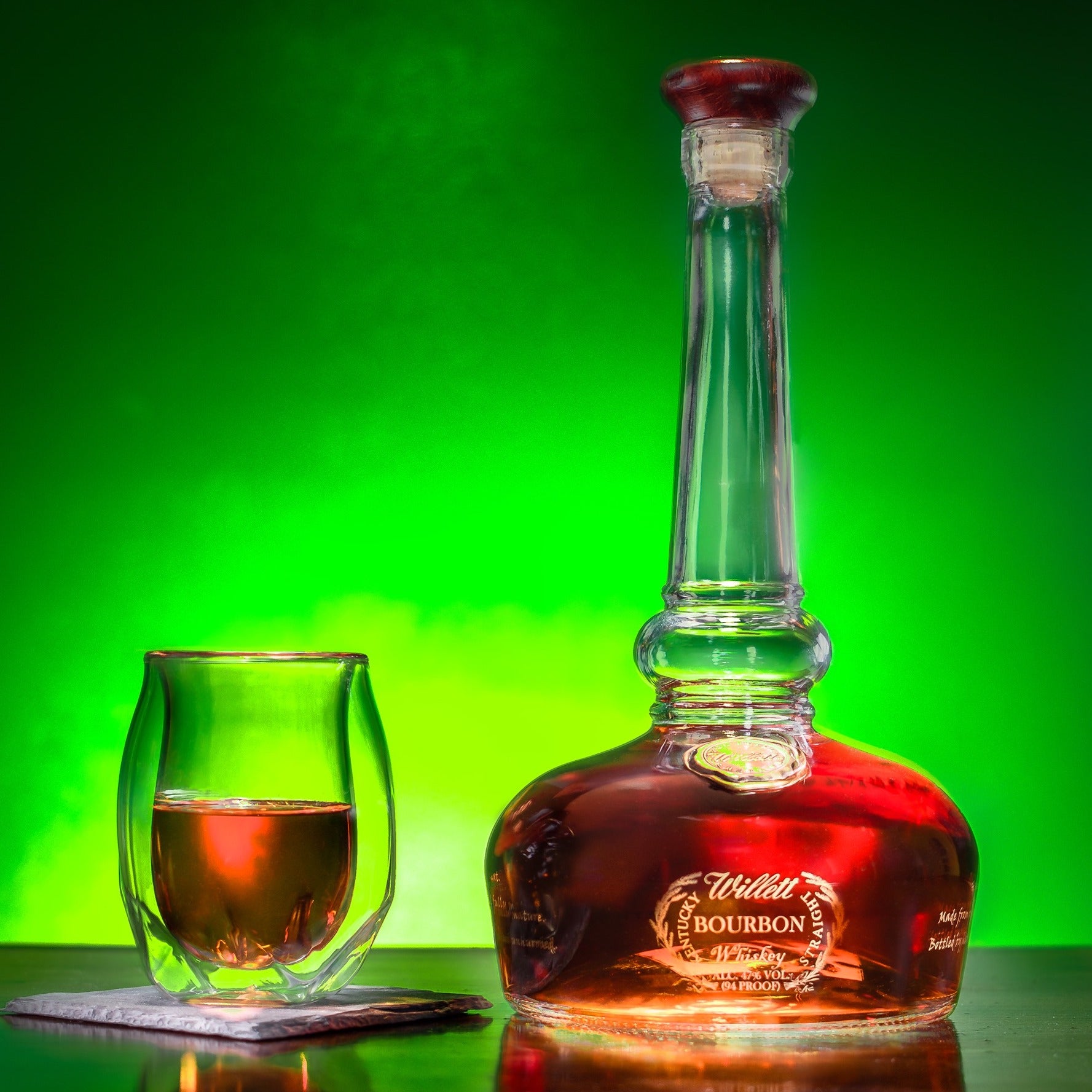 Load image into Gallery viewer, Bourbon bottle and glass on a green background