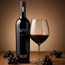 Load image into Gallery viewer, Bottle of Wirra-Wirra-RSW-Shiraz red wine with a glass and grapes on a wooden surface