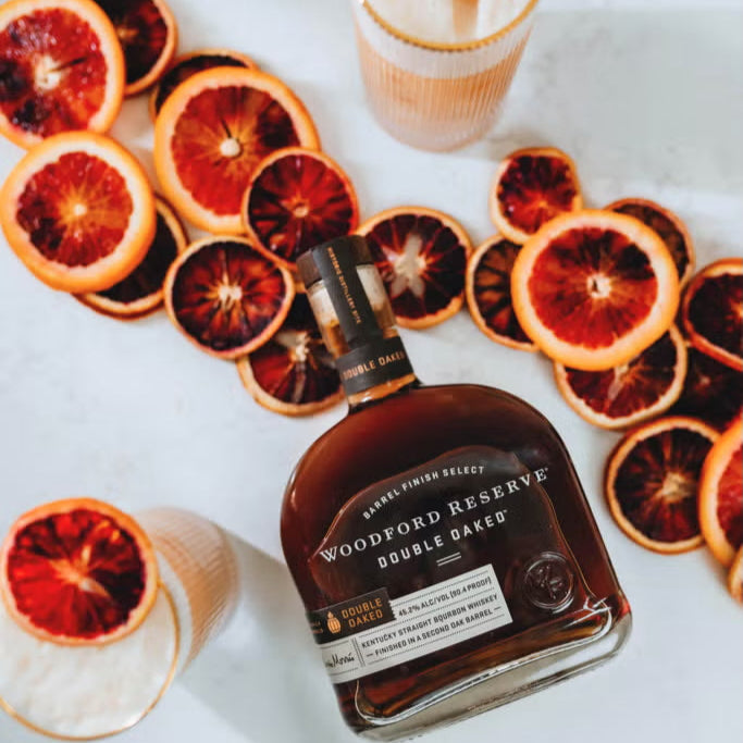 Woodford Reserve bourbon bottle with sliced blood oranges on a white surface