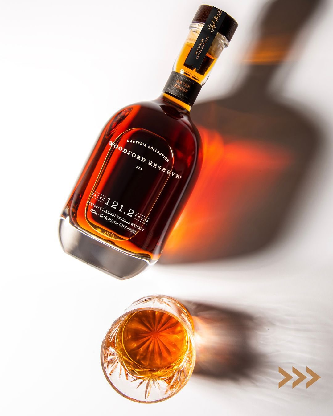 Load image into Gallery viewer, Woodford Reserve Masters Collection Batch Proof Bourbon Whiskey bottle with a glass of whiskey on a white background