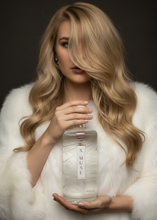 Load image into Gallery viewer, Woman holding a bottle labeled &#39;XMUSE&#39; against a dark background