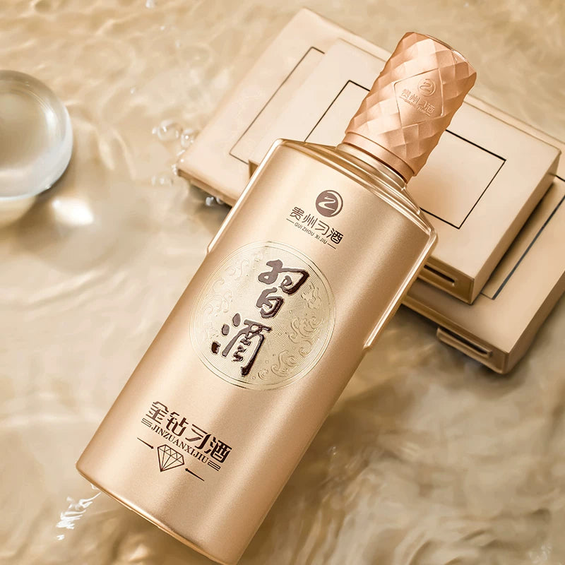 Load image into Gallery viewer, Xijiu Jin Zuan Baijiu 500ml  gold bottle with textured cap on a reflective surface