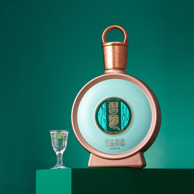 Load image into Gallery viewer, A bottle of Xijiu JunPin Baijiu 53% 500ml  next to a small sipping glass