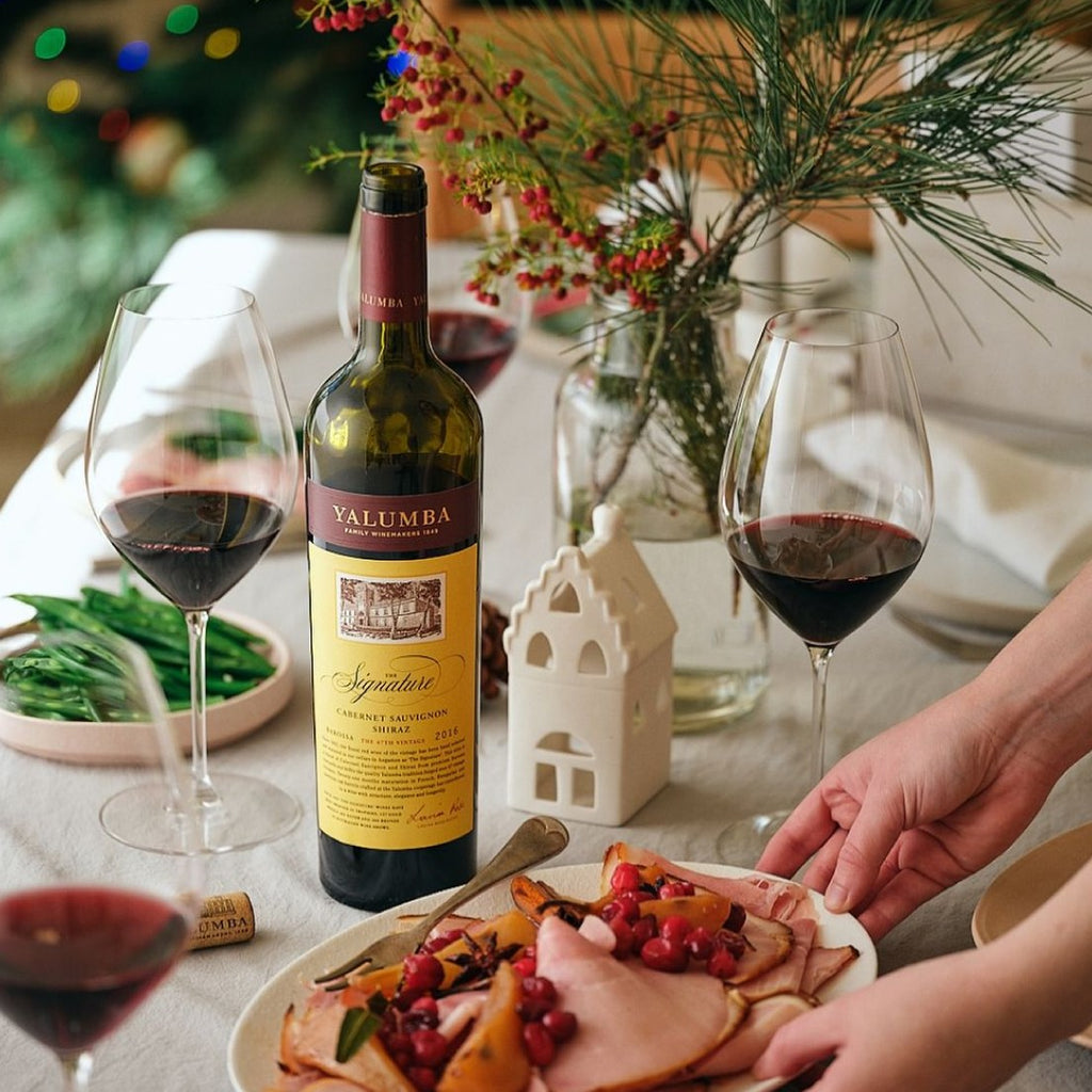 Yalumba The Signature Cabernet Sauvignon Shiraz bottle with glasses and food on a table