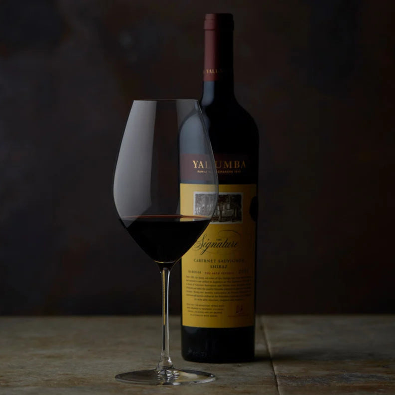 Bottle of Yalumba The Signature Cabernet Sauvignon Shiraz and glass with a dark background