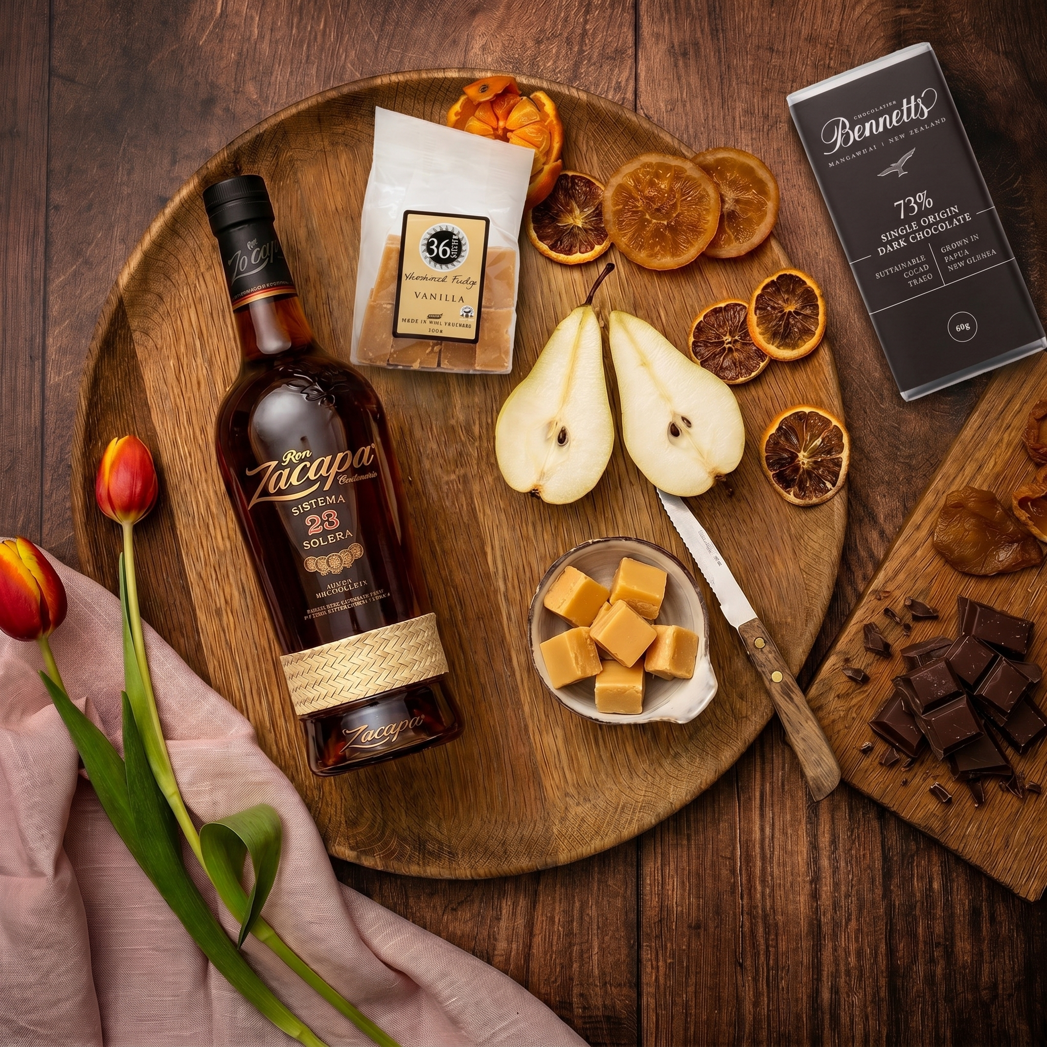 Load image into Gallery viewer, Wooden tray with a bottle of Zacapa 23 year old rum, dried fruits, pears, and chocolate on a wooden surface.
