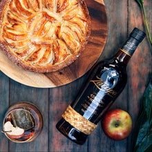 Load image into Gallery viewer, Apple pie on a wooden board with a bottle of Zacapa Edicion Negra Rum and an apple on a rustic wooden table.