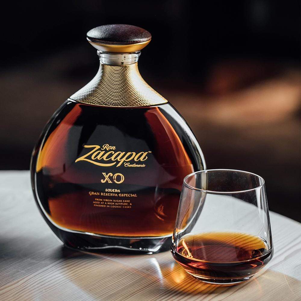 Load image into Gallery viewer, Ron Zacapa XO rum bottle with a glass of rum on a wooden surface