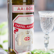 Load image into Gallery viewer, A bottle of Aalborg Akvavit and a snaps on a table