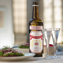 Load image into Gallery viewer, Aalborg beer bottle with glasses and snacks on a table