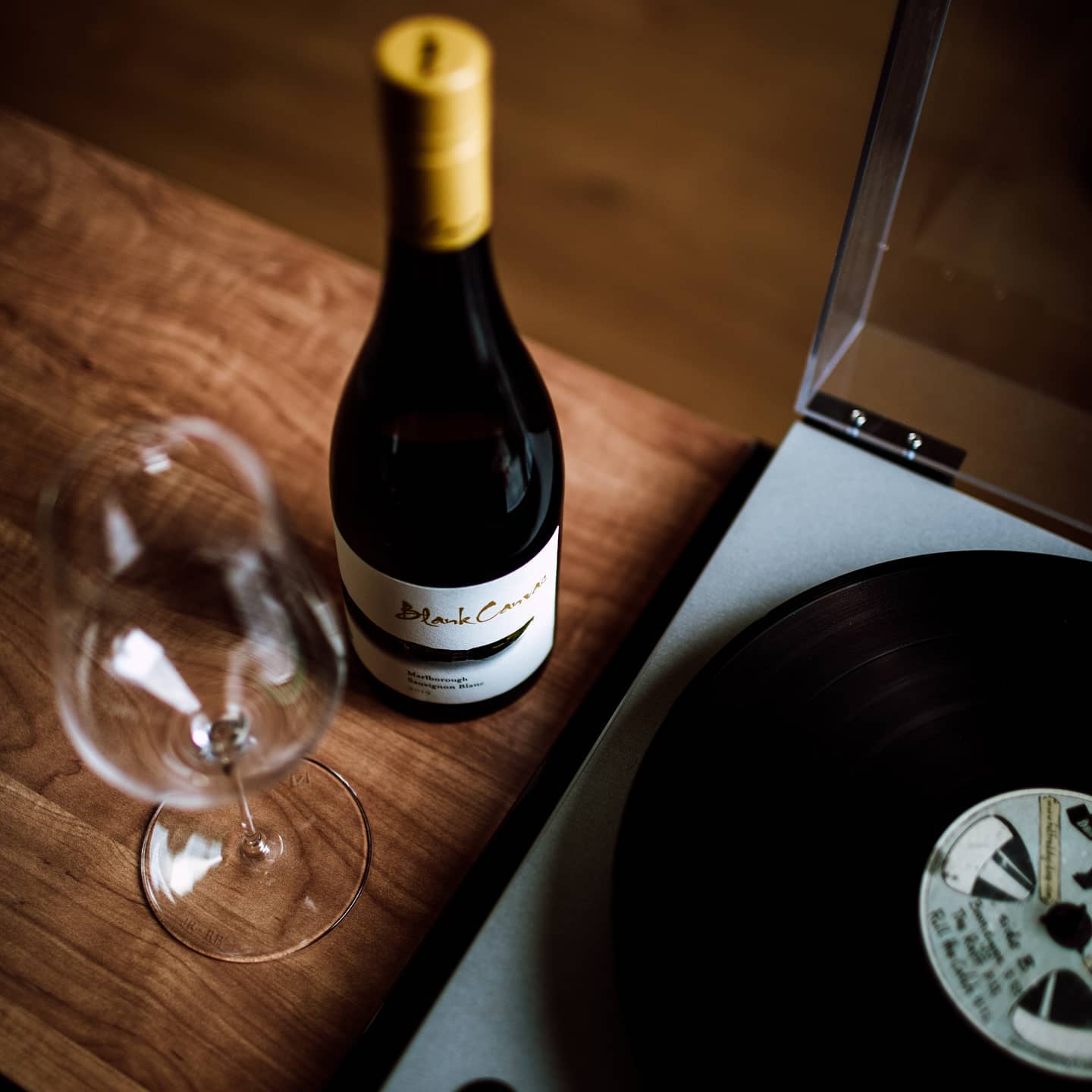 Load image into Gallery viewer, Wine bottle, glass, and vinyl record on a wooden surface