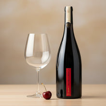 Load image into Gallery viewer, church_road_1_syrah red wine bottle with a cherry and glass on a beige background