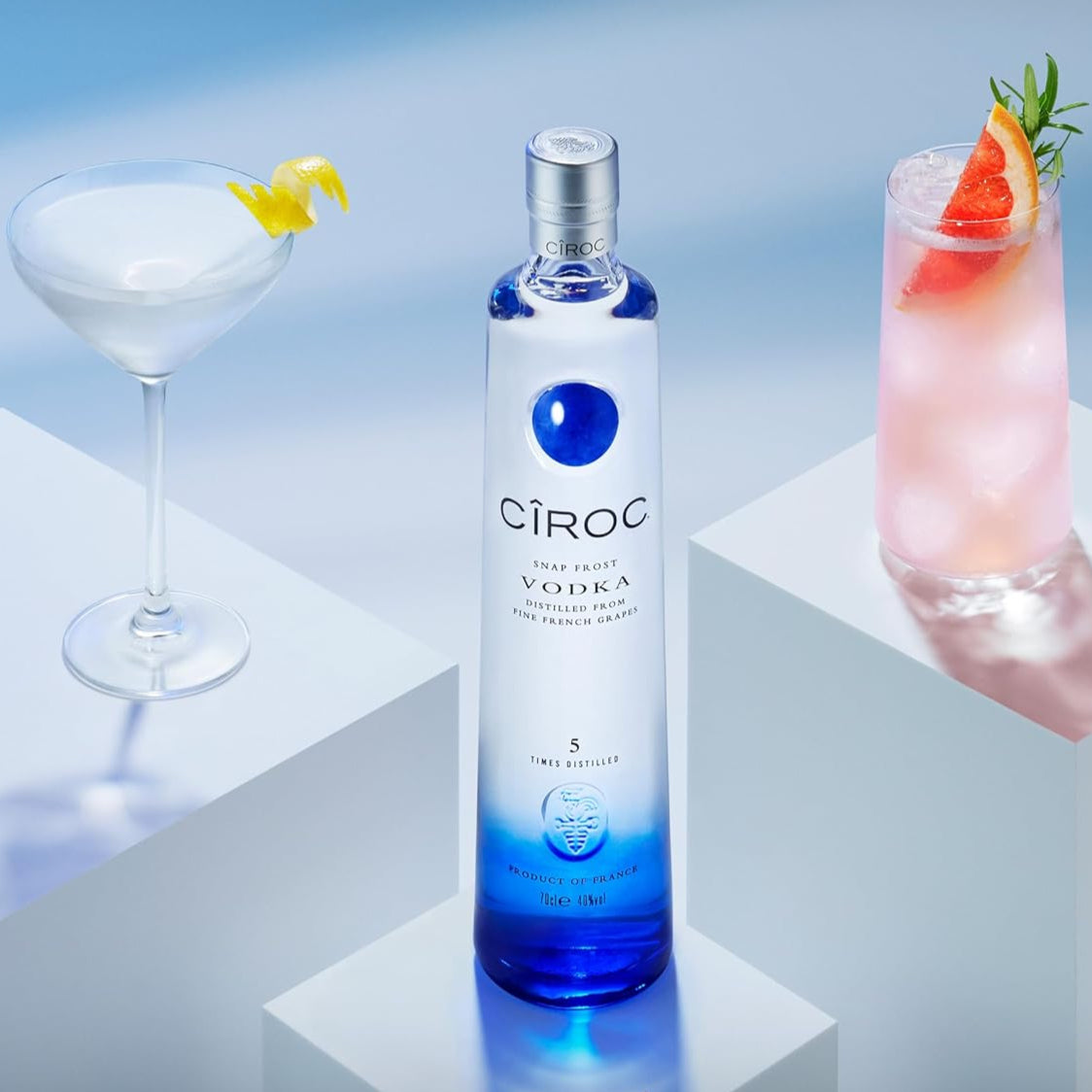 Load image into Gallery viewer, Ciroc vodka bottle with two cocktails on a gradient blue background